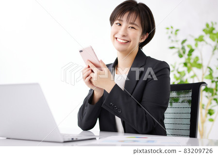 Business woman using a smartphone in the office 83209726