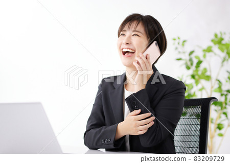 Business woman using a smartphone in the office Business woman using a smartphone in the office 83209729