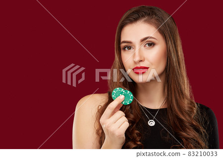 Pretty long hair woman in black dress holding chips for gambling 83210033
