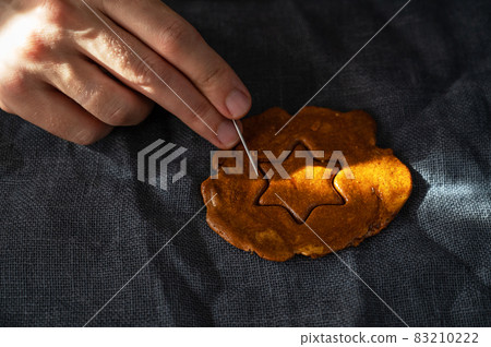 Men's hands closeup scratch and break brown sugar caramel candy 83210222