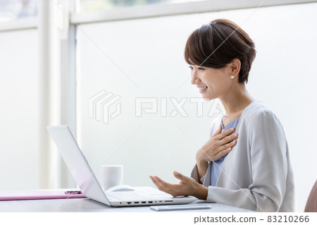 A smiling business woman making a video call A smiling business woman making a video call 83210266