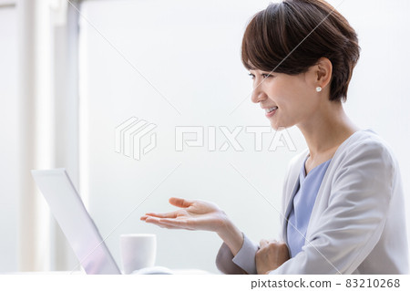 A smiling business woman making a video call A smiling business woman making a video call 83210268
