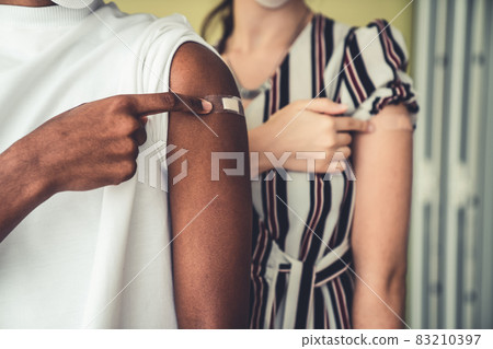 Diverse group of people showing COVID-19 vaccine bandage merrily 83210397