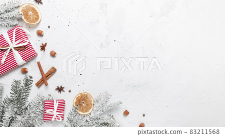 Christmas flat lay top view on white gray concrete background table with glass cup or mug of Mulled Wine, present red gift boxes, decorations, cinnamon sticks, hazelnut, dried or sublimated orange 83211568