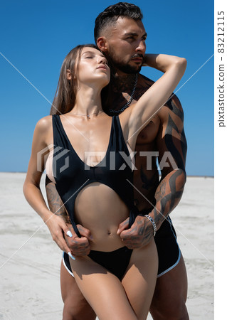 Sexy couple embracing on beach in summer 83212115