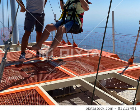 Concept of Extreme Sports and Fun. The instructor helps a man to jump with a rope Concept of Extreme Sports and Fun. The instructor helps a man to jump with a rope 83212491