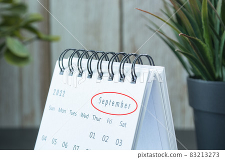 Blurred white September 2022 calendar with potted plant. New Year Concept Blurred white September 2022 calendar with potted plant. New Year Concept 83213273