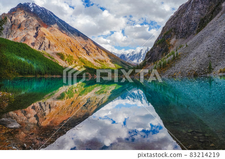 Picturesque mountain lake in the dramatic day, Altai. Beautiful reflection of mountains, sky and white clouds. 83214219