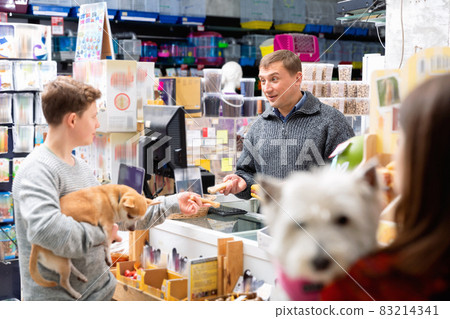 Male seller communicates with buyer as teenager in pet store Male seller communicates with buyer as teenager in pet store 83214341