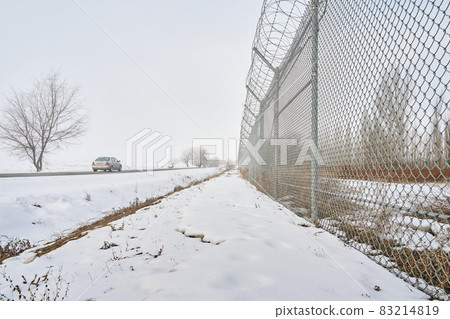 Fence with barbed wire on the border in winter time. Fence with barbed wire on the border in winter time. 83214819