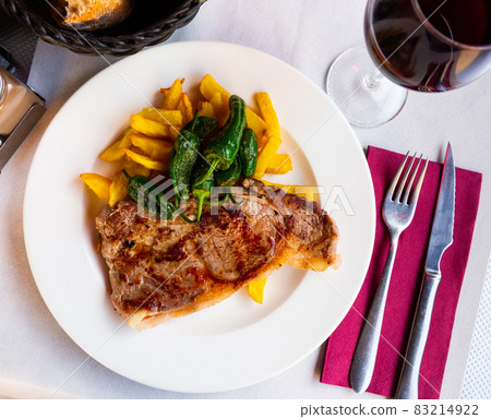 Beef steak with fries and grilled padron peppers 83214922