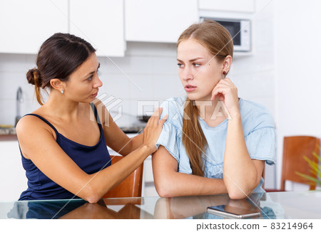 Upset young women discussing, quarrel at home kitchen indoor Upset young women discussing, quarrel at home kitchen indoor 83214964