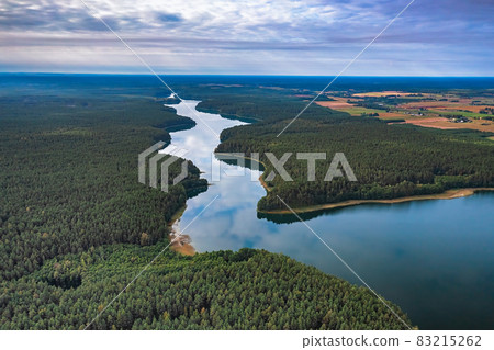 Aerial view of Ancia lake in Lithuania, shiny reflection of sky with clouds in the water of the lake 83215262