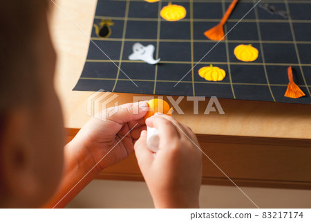 Preschooler boy making board game field for Halloween game 83217174