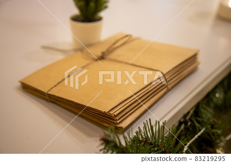 bunch of letters to Santa Claus made of craft paper tied with a rope lie next to Christmas decorations and a Christmas tree bunch of letters to Santa Claus made of craft paper tied with a rope lie next to Christmas decorations and a Christmas tree 83219295