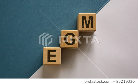 Wood cubes with acronym 'EGM' - 'extraordinary general meeting' stacking as step stair on paper blue and white background, copy space. Business concept. 83219330