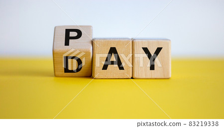 Turned a cube and changed the word 'Pay' to 'Day'. Beautiful yellow table. White background. Business concept. Turned a cube and changed the word 'Pay' to 'Day'. Beautiful yellow table. White background. Business concept. 83219338