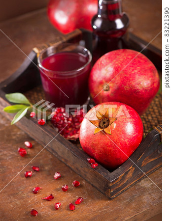 pomegranate juice and pomegranate fruits on a wooden background pomegranate juice and pomegranate fruits on a wooden background 83221390