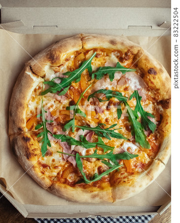 Close-up of pizza with bacon in a disposable dish. Top view of takeaway food in a fast food cafe. On photo - mozzarella cheese, tomatoes, and red basil. The classic recipe. Food for family and Close-up of pizza with bacon in a disposable dish. Top view of takeaway food in a fast food cafe. On photo - mozzarella cheese, tomatoes, and red basil. The classic recipe. Food for family and 83222504