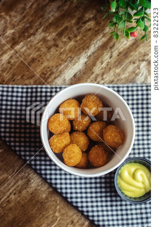 Close-up of potato balls prepared in a fast food restaurant. Barizl national cuisine. Food in a cardboard box. Takeout food. Round buns with potatoes and cheese. Close-up of potato balls prepared in a fast food restaurant. Barizl national cuisine. Food in a cardboard box. Takeout food. Round buns with potatoes and cheese. 83222523
