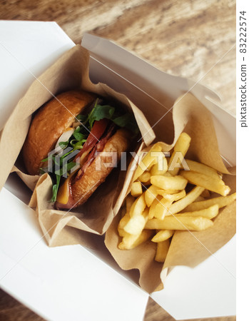 Close-up of a standard burger and french fries. Adult fast food in a restaurant or cafe. Macro photo of burger ingredients with meat, cheese and herbs. Eco burgers for the whole family Close-up of a standard burger and french fries. Adult fast food in a restaurant or cafe. Macro photo of burger ingredients with meat, cheese and herbs. Eco burgers for the whole family 83222574