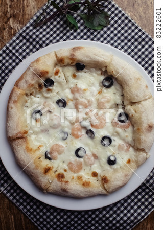 Close-up of pizza with shrimps. Seafood and vegetarian food. Italian food in restaurants and cafes. The concept of marine ingredients in meal preparation. Close-up of pizza with shrimps. Seafood and vegetarian food. Italian food in restaurants and cafes. The concept of marine ingredients in meal preparation. 83222601
