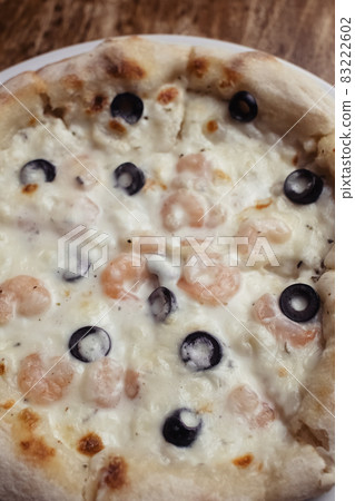 Close-up of pizza with shrimps. Seafood and vegetarian food. Italian food in restaurants and cafes. The concept of marine ingredients in meal preparation. Close-up of pizza with shrimps. Seafood and vegetarian food. Italian food in restaurants and cafes. The concept of marine ingredients in meal preparation. 83222602
