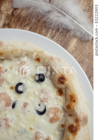 Close-up of pizza with shrimps. Seafood and vegetarian food. Italian food in restaurants and cafes. The concept of marine ingredients in meal preparation. Close-up of pizza with shrimps. Seafood and vegetarian food. Italian food in restaurants and cafes. The concept of marine ingredients in meal preparation. 83222603