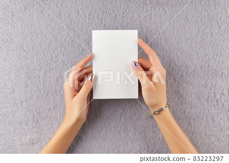 Beautiful groomed womans hands with matte lavender nail design on furry gray background. Manicure, pedicure beauty salon concept 83223297