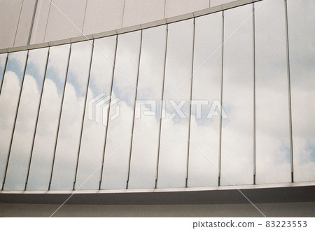The blue sky reflected in the glass of the building The blue sky reflected in the glass of the building 83223553
