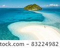 Happy woman standing on a perfect beach 83224982