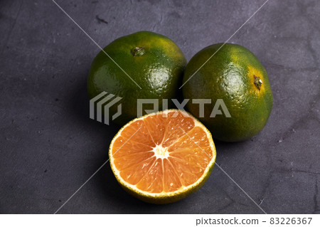 Fresh and juicy green mandarins on a dark background. Vegetarian food concept 83226367