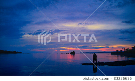 A couple watching the sunset from the surface of the water A couple watching the sunset from the surface of the water 83226656