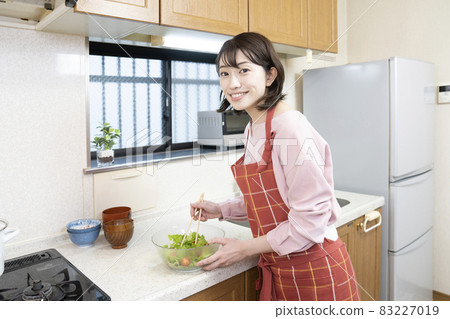 Woman making salad in the kitchen Woman making salad in the kitchen 83227019