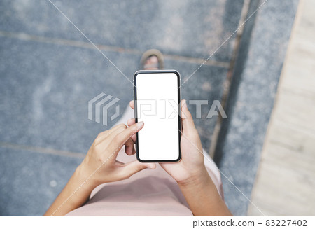 woman hand using phone white blank screen walking on path way woman hand using phone white blank screen walking on path way 83227402