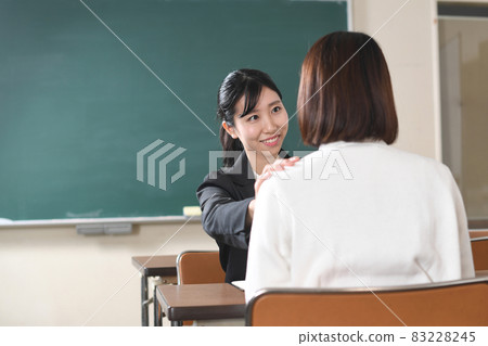 Image of interview (consultation) between a female teacher and a student in uniform 83228245