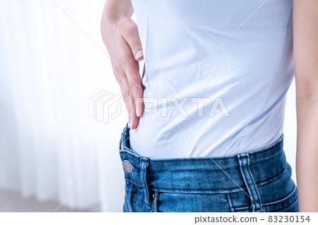 A woman holding her stomach [parts cut] 83230154