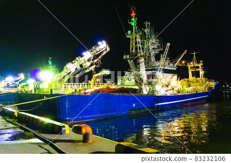 Night view photo of a fishing boat moored in the harbor at night_32 83232106