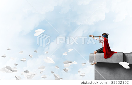 Girl power concept with cute kid guardian against cloudscape background . Mixed media Girl power concept with cute kid guardian against cloudscape background . Mixed media 83232592