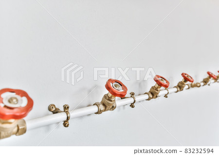 White water pipe with red valves in a row White water pipe with red valves in a row 83232594