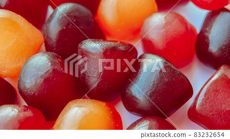 Close-up texture of red, orange and purple multivitamin gummies on white background. Healthy lifestyle concept Close-up texture of red, orange and purple multivitamin gummies on white background. Healthy lifestyle concept 83232654