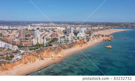 Aerial view of the wide and crowded Portuguese famous Rocha beach in Portimao, Algarve, Portugal. Drone shot 83232732