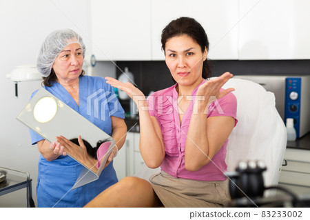 Portrait of an outraged young female patient in a clinic after procedures Portrait of an outraged young female patient in a clinic after procedures 83233002