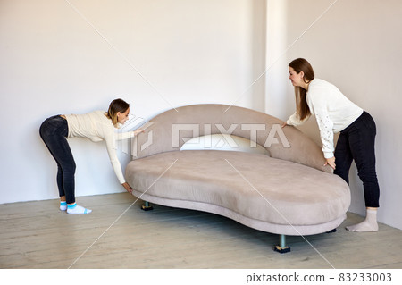 Couple move to new flat and moving furniture indoors. Couple move to new flat and moving furniture indoors. 83233003
