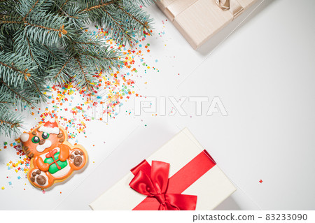 Christmas background with gift and gingerbread . Holiday mood card. Top view, copy space. Family traditions, DIY, celebration concept. Festive background with homemade gingerbread cookies. 83233090