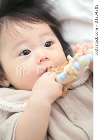6 month old baby girl biting a tooth-hardening toy 6 month old baby girl biting a tooth-hardening toy 83234285