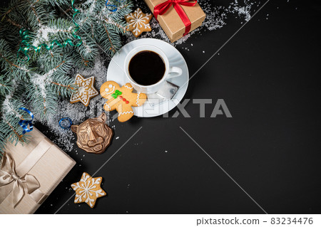 Christmas and New Year decoration composition. Top view of fur-tree branches on dark background with place for your text. Cups of fragrant coffee with gingerbread and chokolate. 83234476