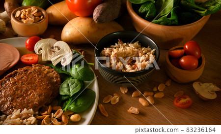 Vegan meat with brown rice, nuts and vegetables on a wooden table. 83236164