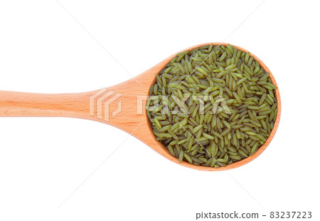 brown rice in wood spoon on white background 83237223