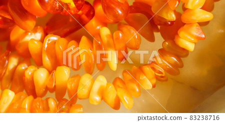 Sunny beads of fire amber. Natural gemstone background, jewelry concept 83238716